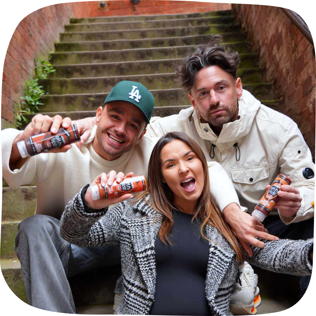 Oh My Glaze founders Scott, Robyn and Adam together holding Oh My Glaze sauce bottles in Manchester